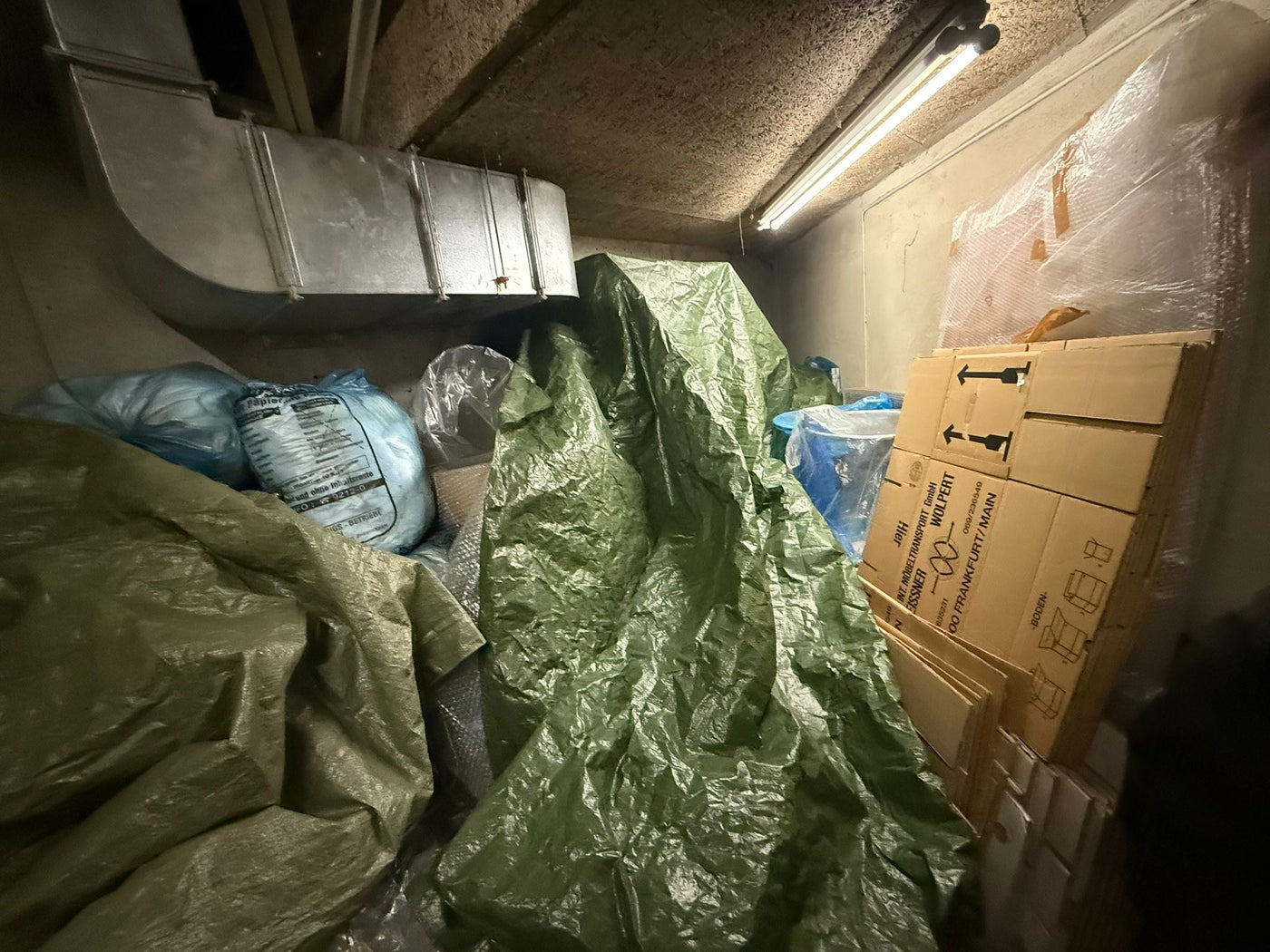 Vollgestellter Kellerraum in Nauheim mit Planen und Kartons vor der Entrümpelung